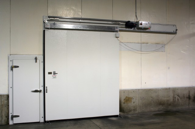 Photo of a cold storage fruit facility in Yakima, Washington with a closed R-Plus Doors Horizontal Sliding Door powered by ICC-5 Controller and a Swing Door.