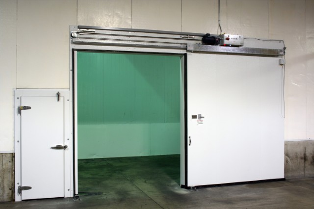 Photo of a cold storage fruit facility in Yakima, Washington with an open R-Plus Doors Horizontal Sliding Door powered by ICC-5 Controller and a Swing Door.