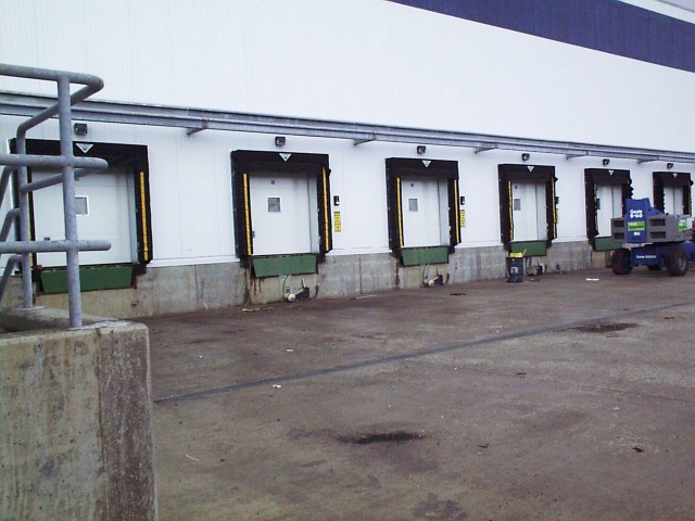 Photo of a series of vertical doors exterior at cold storage warehouse.